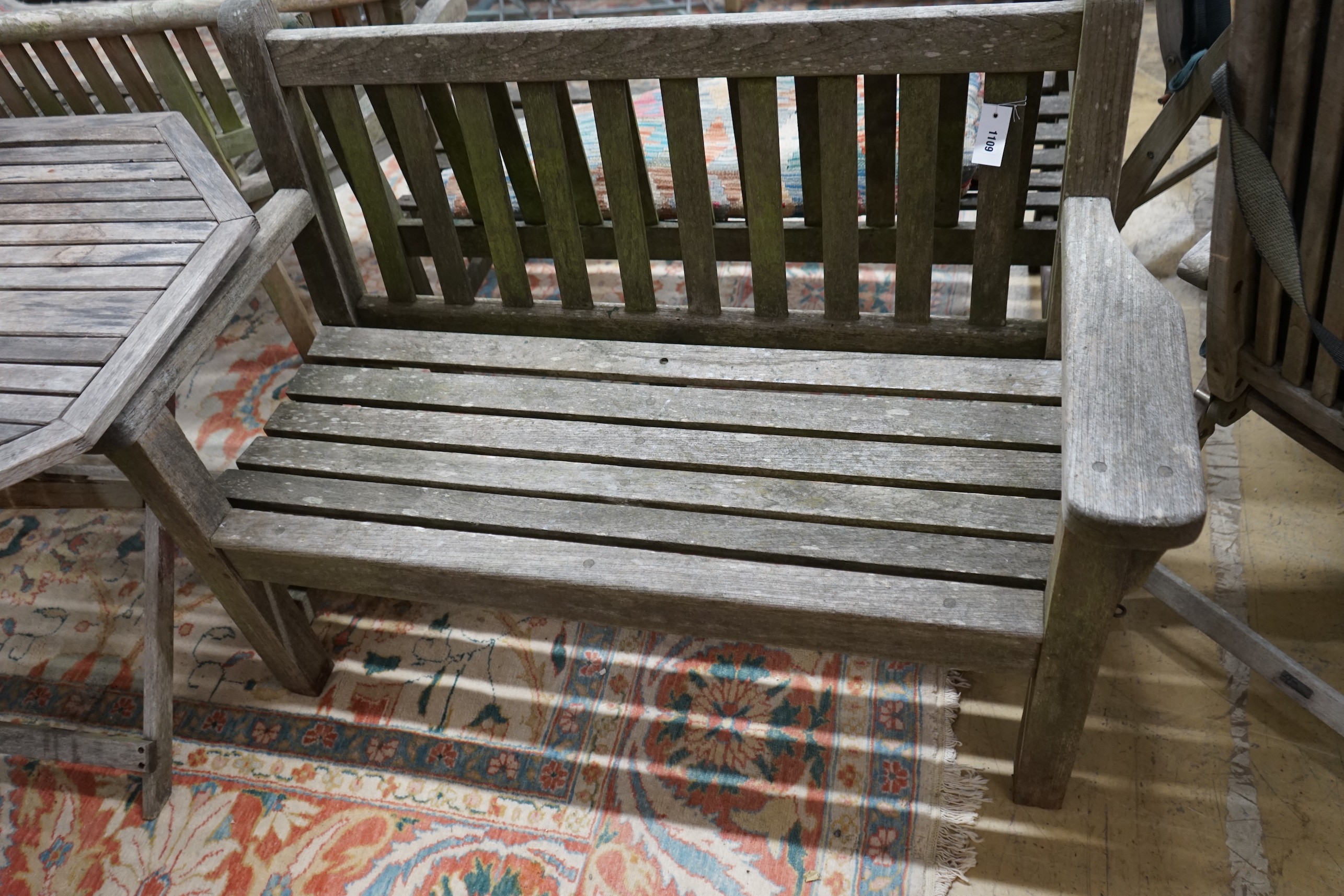 A weathered teak garden bench and an octagonal garden table, width 100cm, height 69cm